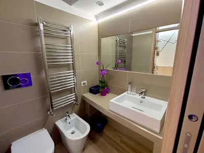 a bathroom with a sink and a toilet and a mirror at Appartamento in Via dei 3 Pupazzi 12 in Rome