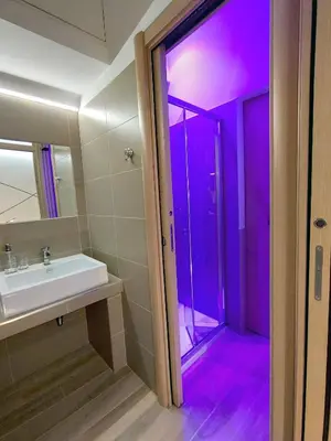 a bathroom with a sink and purple lighting at Appartamento in Via dei 3 Pupazzi 12 in Rome