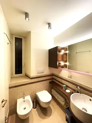 a bathroom with a toilet and a sink and a mirror at Di casa al Colosseo in Rome