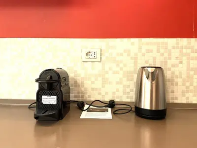 a coffeemaker sitting on top of a counter next to a tea kettle at Di casa al Colosseo in Rome
