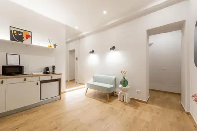 a white kitchen with a chair and a table at Ventuno Dei Luxury Suites San Giovanni in Rome