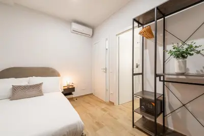 a bedroom with a white bed and a glass shelf at Ventuno Dei Luxury Suites San Giovanni in Rome