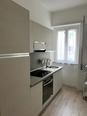 a white kitchen with a sink and a window at CAFE Portonaccio apartment in Rome