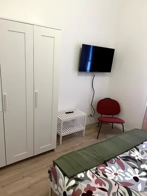 a bedroom with a bed and a tv on a wall at CAFE Portonaccio apartment in Rome