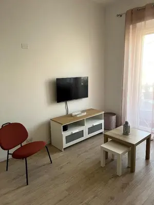 a living room with a tv and a chair and a table at CAFE Portonaccio apartment in Rome