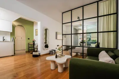 a living room with a green couch and a table at Trastevere Luxury Studio in Rome