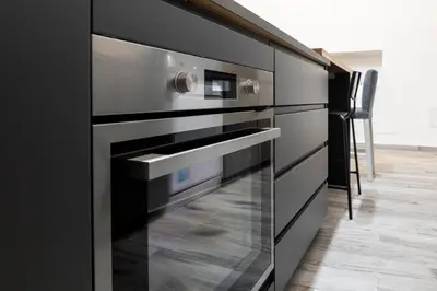 a kitchen with stainless steel ovens in a black kitchen at Luxury suite al Vaticano in Rome