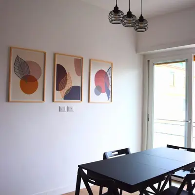 a dining room with a table and four pictures on the wall at Casa Sisto in Rome