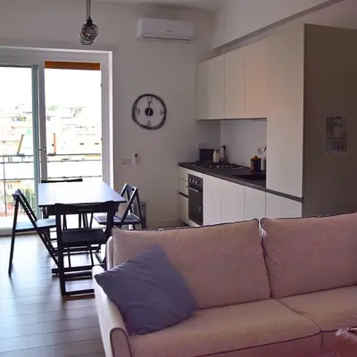 a living room with a couch and a table and a kitchen at Casa Sisto in Rome