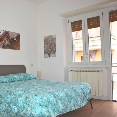 a bedroom with a bed and two windows at Casa Sisto in Rome
