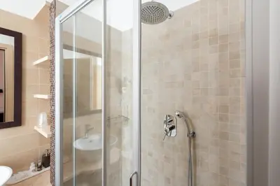 a bathroom with a glass shower with a sink at A Trastevere da M.E. in Rome