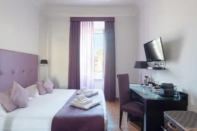a bedroom with a bed and a desk and a television at A Trastevere da M.E. in Rome