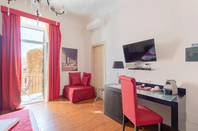 a living room with a desk and a red chair at A Trastevere da M.E. in Rome