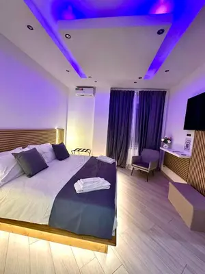 a bedroom with a large bed with purple lighting at SUITE56Roma in Rome