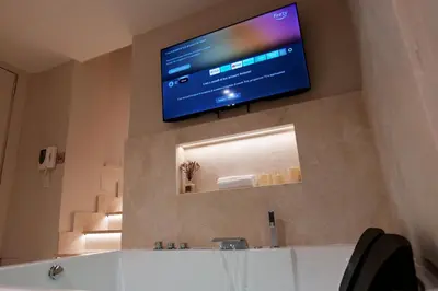 a flat screen tv on the wall of a bathroom at HeySuite Classic - Luxury House - Navona in Rome