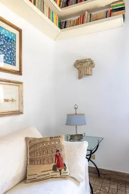 a room with a couch with a pillow and a table at NOSTROMONDO Prestigious 2 bedrooms Domus in Forum Area in Rome