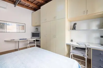 a bedroom with white cabinets and a desk and a bed at NOSTROMONDO Prestigious 2 bedrooms Domus in Forum Area in Rome