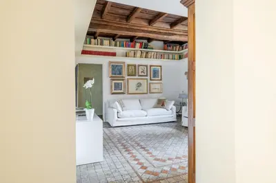 a living room with a white couch and a table at NOSTROMONDO Prestigious 2 bedrooms Domus in Forum Area in Rome