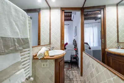 a bathroom with a sink and a mirror and a tub at NOSTROMONDO Prestigious 2 bedrooms Domus in Forum Area in Rome