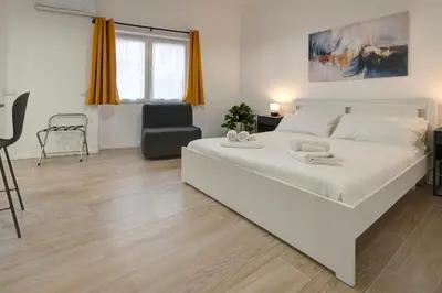 a bedroom with a large white bed and a chair at Domus Boccea - Vatican Apartment in Rome
