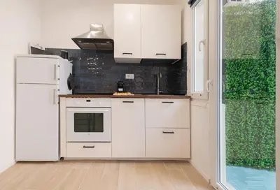 a kitchen with white cabinets and a refrigerator at Domus Boccea - Vatican Apartment in Rome