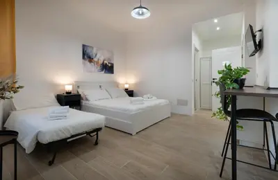 a living room with a white bed and a couch at Domus Boccea - Vatican Apartment in Rome