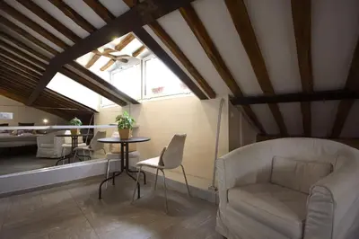 a living room with a chair and a table at Il Nido sui Tetti di Piazza Navona in Rome