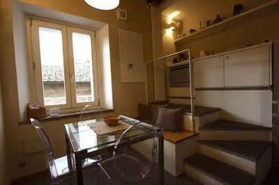 a small kitchen with a glass table and a window at Il Nido sui Tetti di Piazza Navona in Rome