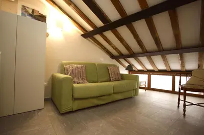 a green couch in a living room with a wooden ceiling at Il Nido sui Tetti di Piazza Navona in Rome