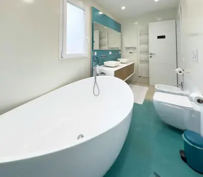 a bathroom with a large white tub and a sink at Vatican Luxury Duplex in Rome