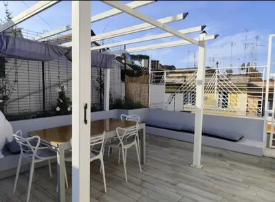 a patio with a table and chairs on a balcony at Vatican Luxury Duplex in Rome