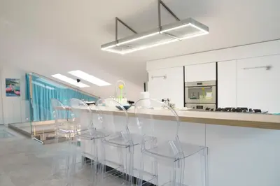 a kitchen with a bar with chairs and a counter at Vatican Luxury Duplex in Rome