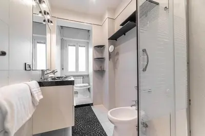 a white bathroom with a toilet and a sink at Desiré Flat - Vatican City - Metro Cipro and WiFi in Rome