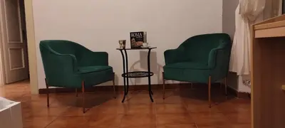 two green chairs and a table in a room at Auror house in Rome