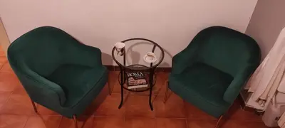 two green chairs and a table in a room at Auror house in Rome