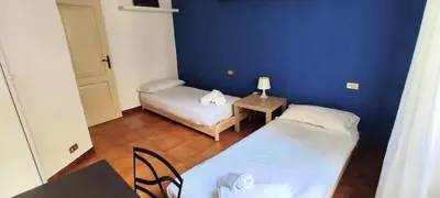 a room with two beds and a blue wall at Auror house in Rome