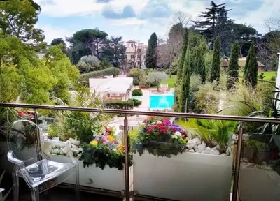 a balcony with a view of a garden and a pool at Exceptional near Vatican flat with swimming pool in Rome