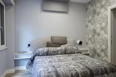 a bedroom with a bed with a blue and white comforter at Roma Vaticano Deluxe Apartment in Rome