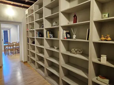 a large book shelf in a room with a dining room at Be Your Home - CasAngelica in Rome