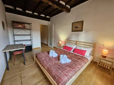 a bedroom with a bed with red pillows and a desk at Be Your Home - CasAngelica in Rome