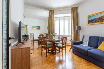 a living room with a blue couch and a table at iFlat Colosseo Prestige in Rome
