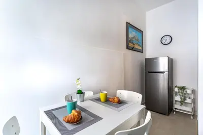 a kitchen with a white table and a refrigerator at iFlat Colosseo Prestige in Rome