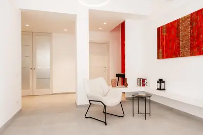 a living room with a white chair and a table at Domus Solis in Rome