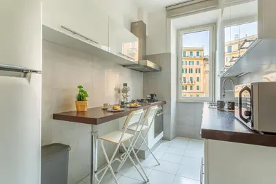 a kitchen with a counter with stools in it at iFlat Vatican Bright & Comfortable Apartment in Rome