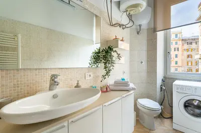 a bathroom with a sink and a washing machine at iFlat Vatican Bright & Comfortable Apartment in Rome