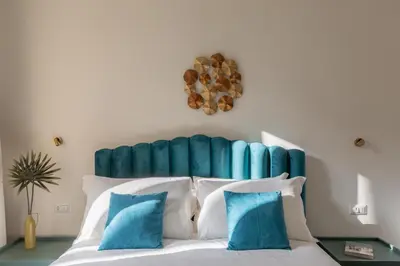 a bedroom with a bed with a blue headboard at iFlat Trastevere Life with Beauty, Elegance & SPA in Rome