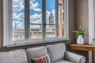 a living room with a couch and a large window at Napoleone 2 bedroom apartment in Rome