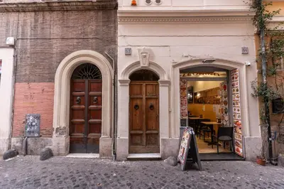 two large wooden doors on a building with a table at Monti Studio Roman Forum in Rome