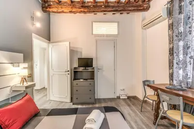 a living room with a bed and a desk at Monti Studio Roman Forum in Rome