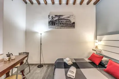 a room with a bed and a desk and a lamp at Monti Studio Roman Forum in Rome